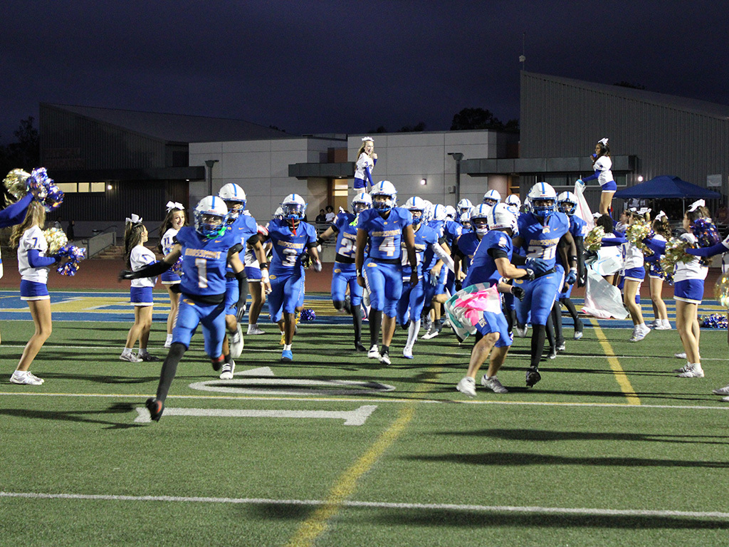 2025 Homecoming Team running onto field